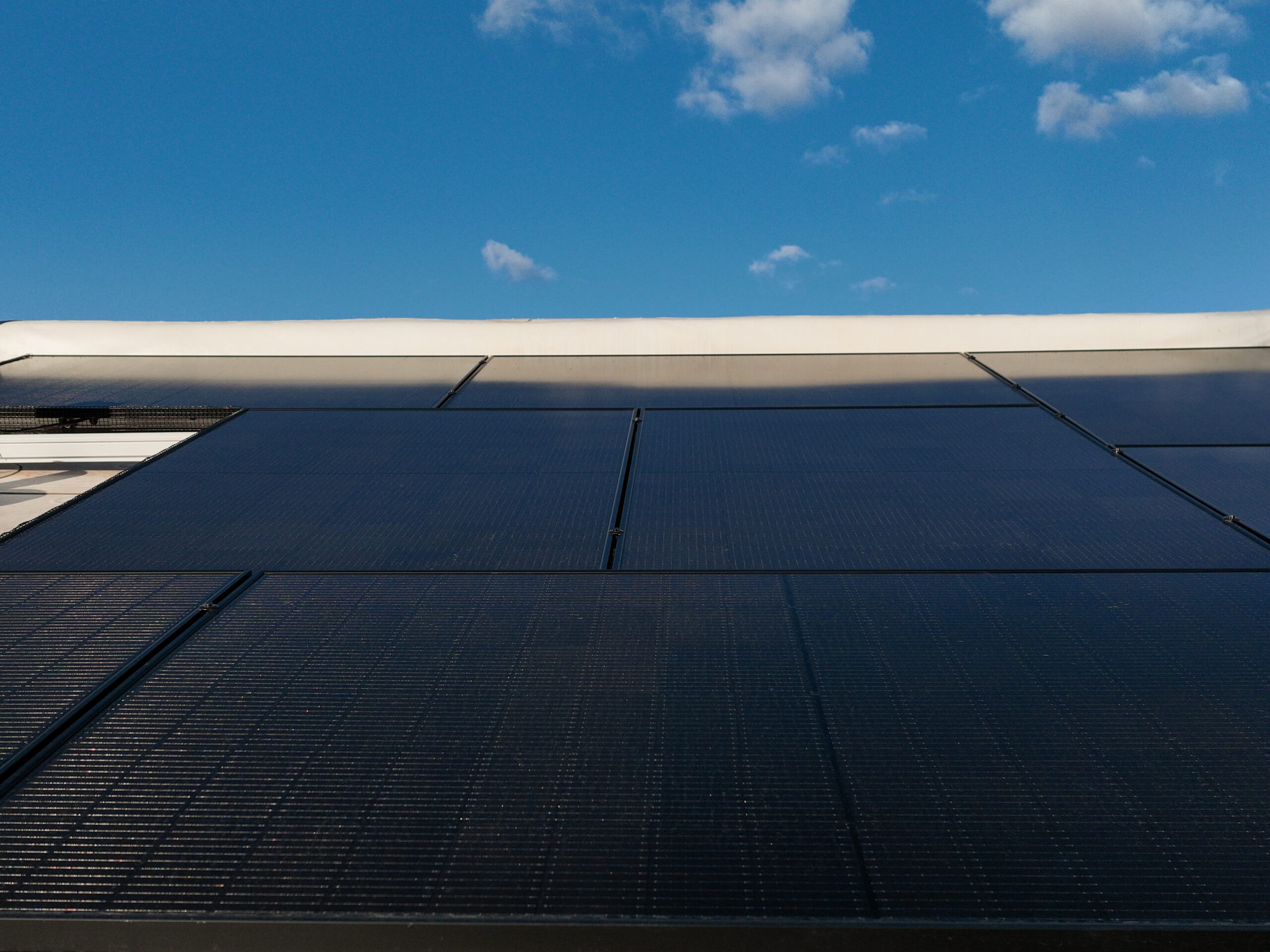 Close-up of solar panels on a roof, against a blue sky