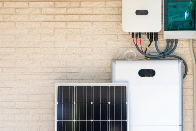 Front view of photovoltaic panel and battery instalation leaning on the beige white wall with no people renewable energy