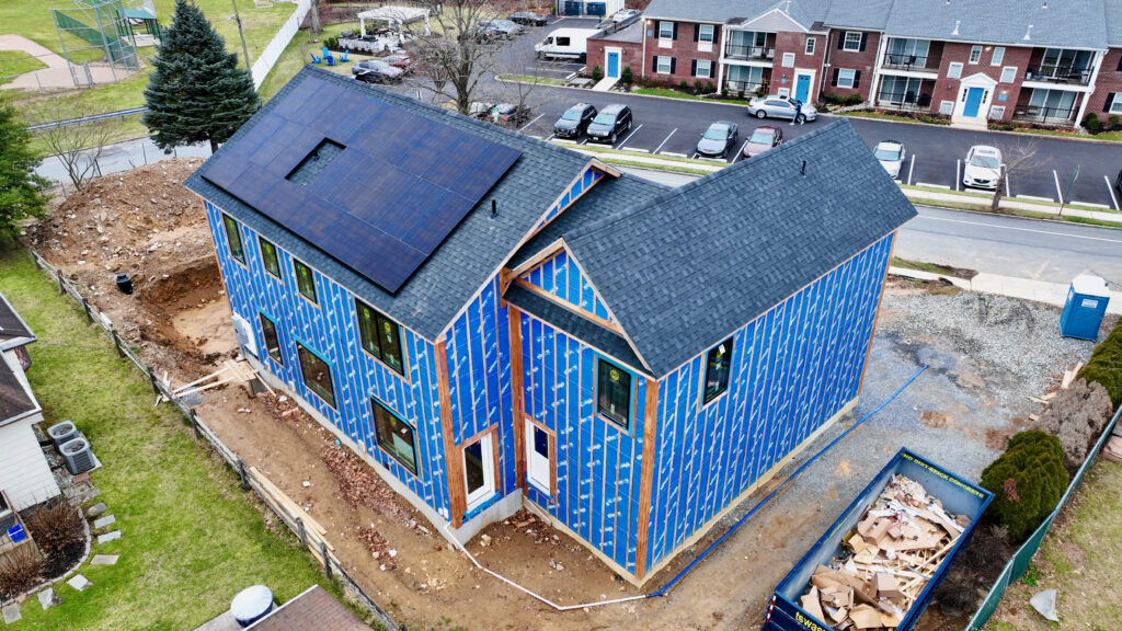 An aerial view of a house with solar panels on the roof showcasing sustainable projects.