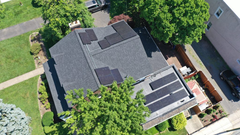 A house with solar panels on the roof projects an aerial view.